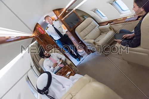 Young middle eastern successful businessmen enjoyed by talking with Arab business partner while sitting in private jet