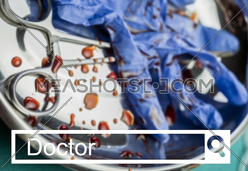 Search in the doctor network, Gloves blue and scissors stained with blood on a tray in an operating theater, conceptual image