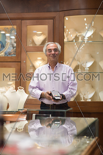 Senior middle eastern successful owner works in his luxury jewelry store