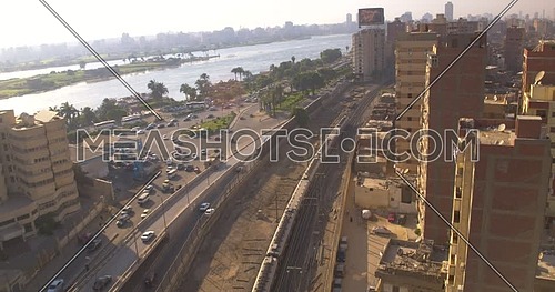 Aerial shot for the city beside the River Nile while Metro Passing by in Cairo at sunset