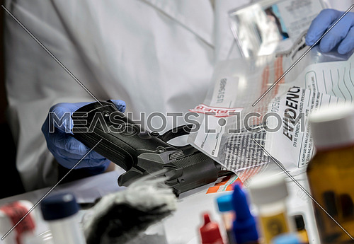 Scientific police officer examining traces of a gun in ballistic laboratory