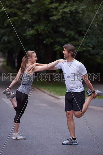 jogging couple warming up and stretching before running