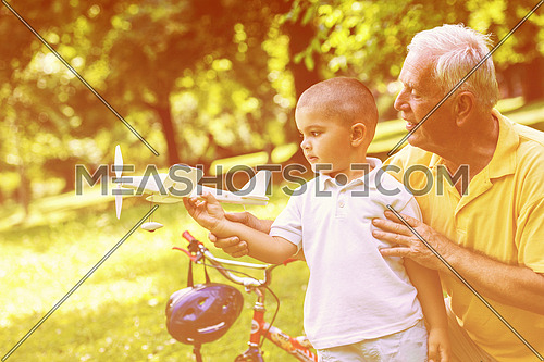 happy grandfather and child have fun and play in park on beautiful  sunny day