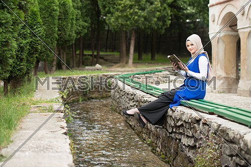 Young Muslim Woman Is Reading The Koran Outdoors