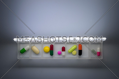weekly pillbox with medication, conceptual image, horizontal composition