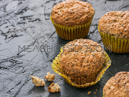 Muffins with chia seeds. Homemade muffin on black concrete textured background