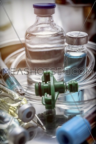 Multiple vial and syringe in a tray metal, conceptual image
