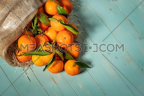Fresh tangerines on blue wooden table. Copy space