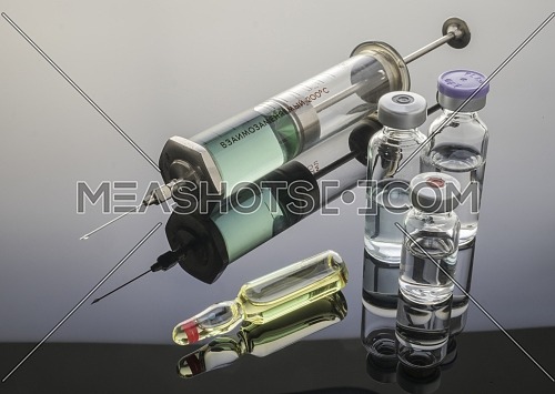Syringe vintage next to vials, conceptual image
