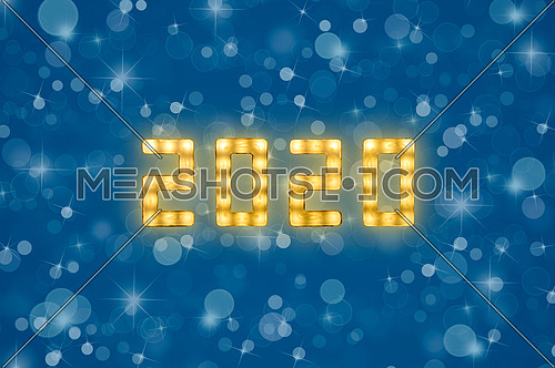 Close up yellow neon glowing bright led light 2020 sign on winter snowflakes and bokeh blue background with copy space