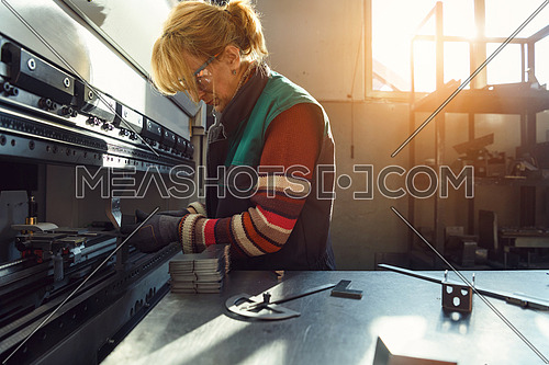 woman working in a modern factory and preparing material for a CNC machine. High quality photo
