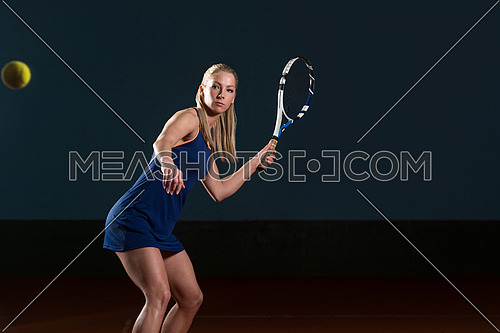 Young Female Tennis Player With Racket Ready To Hit A Tennis Ball