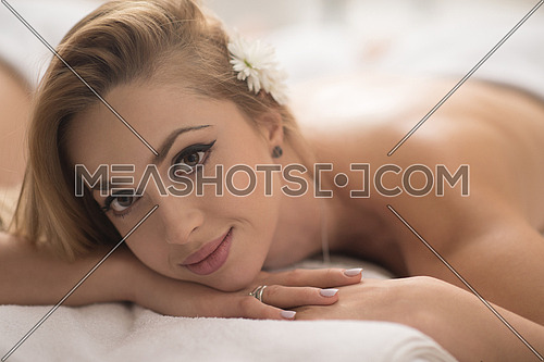 beautiful young woman getting back massage in spa and wellness salon