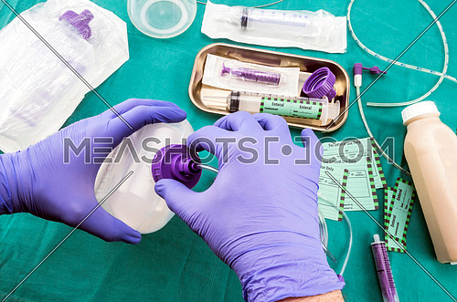 Nurse placed adapter in equipment probe of enteral nutrition, palliative care in hospital, conceptual image, composition hotizontal