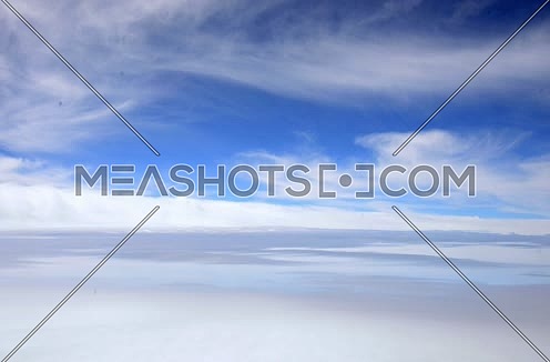 arial view from airplane window showing blue sky and clouds