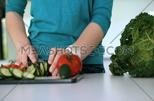 Close up of a young woman slicing tasty nutritious vegetables 