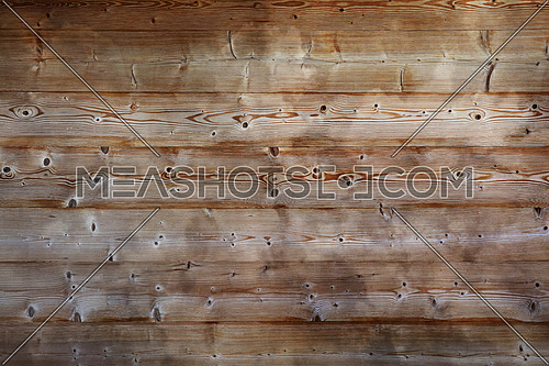 Brown old vintage unpainted wooden horizontal planks wall background texture with aged knotty woodgrain pattern and dark dirty stains, close up