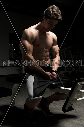 Good Looking And Attractive Young Man With Muscular Body Sitting On Bench And Relaxing In Gym