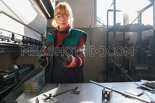 woman working in a modern factory and preparing material for a CNC machine. . High quality photo