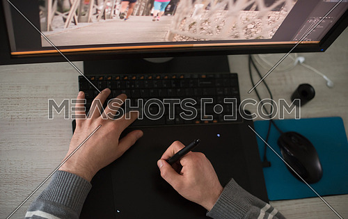 Young graphic designer working on a digital tablet and a computer top view