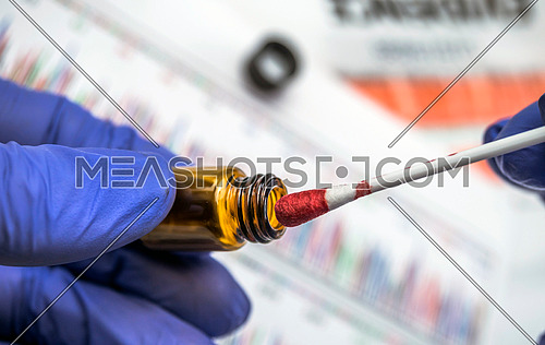 Police expert gets blood sample from glass bottle in Criminalistic Lab, conceptual image