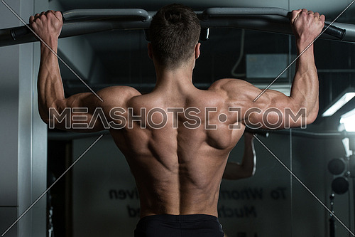 Young Male Athlete Doing Pull Ups - Chin-Ups In The Gym
