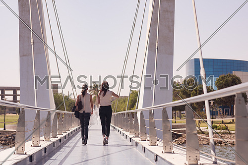 business woman group walking together across modern bridge at early mornig while drinking coffee
