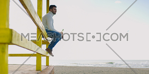 Man Drinking Beer on beach during autumn time