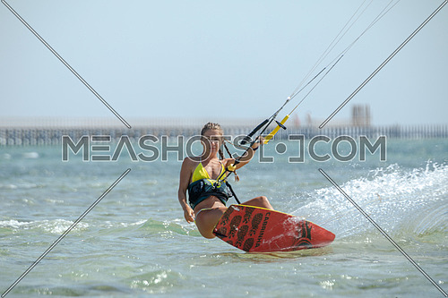Female Kite Surfer while surfing in Red Sea at day.