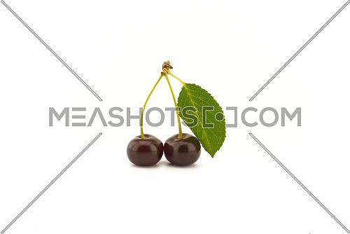 Two ripe cherries with a green leaf isolated on a white background