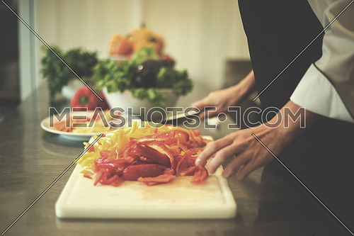 Chef cutting fresh and delicious vegetables for cooking or salad