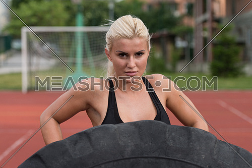 Young Woman Turning Tire Over - Bodybuilding Exercises Truck Tire