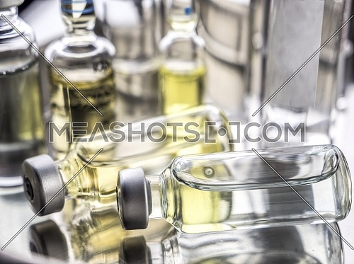 Different types of vials with medication along some syringes in a hospital, conceptual image