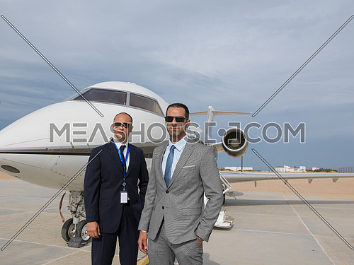 portrait of two successful middle eastern businessman in front of private airplane