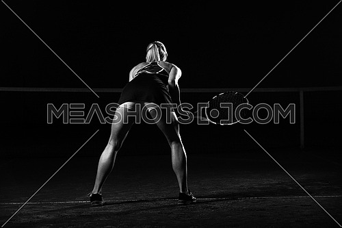 Female Tennis Player With Racket Ready To Hit A Tennis Ball - Isolated On Black