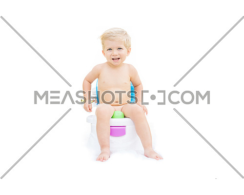 Infant boy, white caucasian smiling and sitting on the potty with white background.