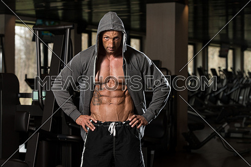 Portrait Of A Physically Fit Man In Hoodie - In Modern Fitness Center - Showing His Six Pack