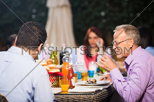 happy middle east family enjoying the beautiful summer evenings with a barbecue in the garden