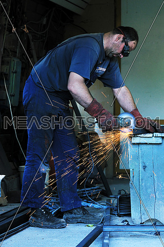 industry worker cut steel with spinning machine and spark