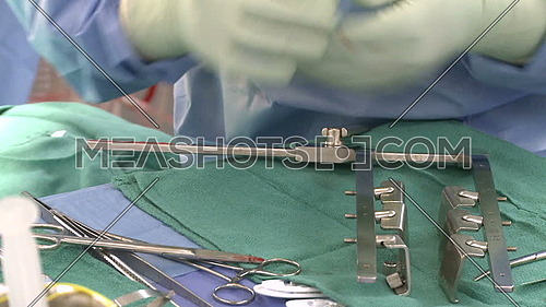 Close shot for a hand and a Rib spreader being prepared for surgery on surgical tray