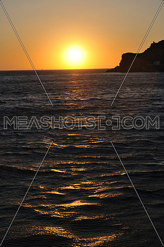 romantic sunset at sea eith tourist and travel boats on horizon