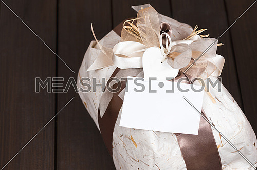 In the picture a gift bag with copy space on the wooden background.