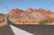 A car drives along a desert road