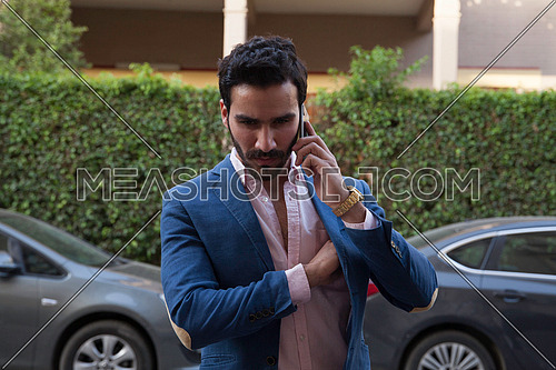 A young business man talking on the phone in the street