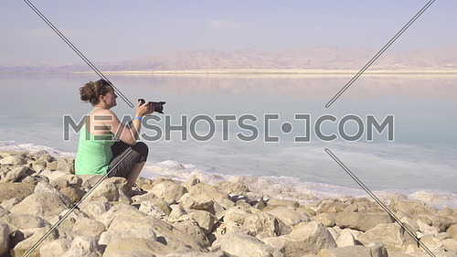 Female tourist taking pictures of Dead Sea