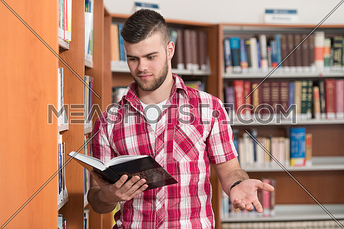 Funny And Crazy Man Reading From Book In The Library