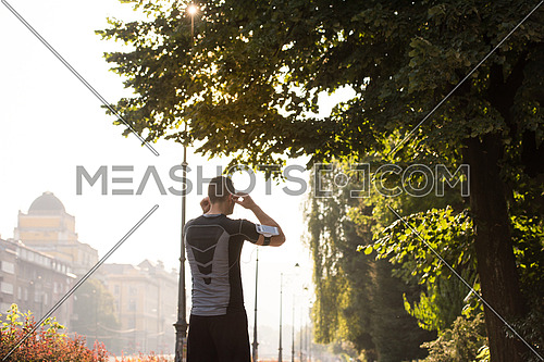 young sporty man jogging at sunny morning in the city