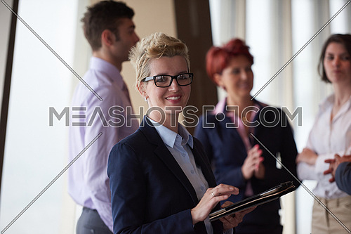 diverse startup business people group standing together as team  in modern bright office interior  with blonde  woman with glasses  in front as leader