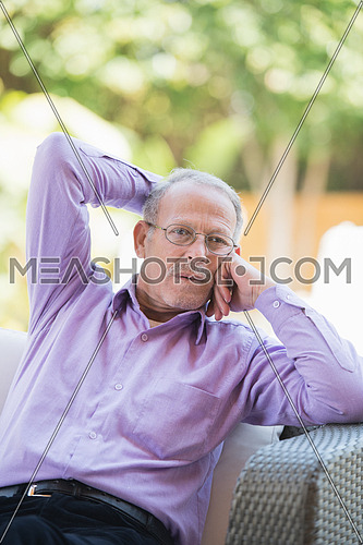 portrait of an elderly middle eastern man to enjoy the sunny summer morning at the pool