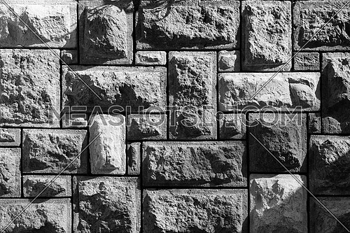 Black white shot of background of pattern of decorative uneven stone wall surface